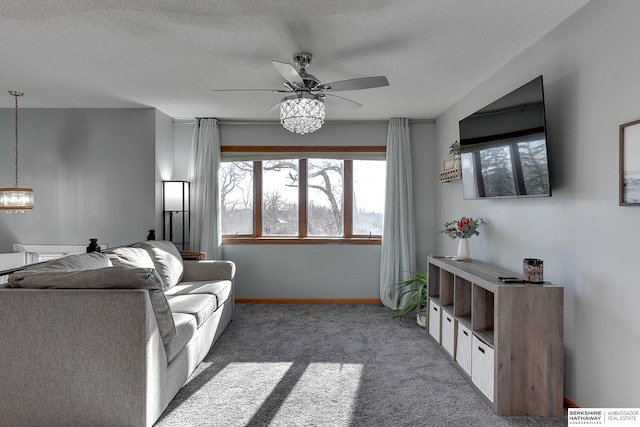 living area featuring a textured ceiling, ceiling fan, carpet, and baseboards