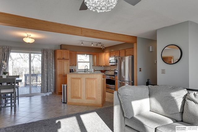 kitchen with a center island, stainless steel appliances, open floor plan, light tile patterned flooring, and a sink