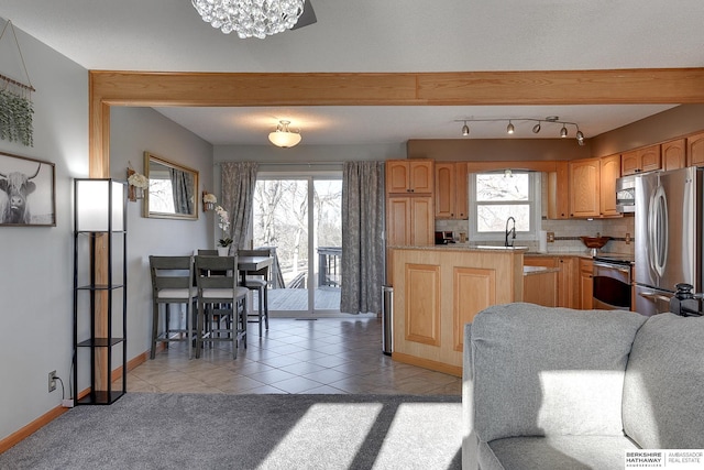 kitchen with light tile patterned flooring, light carpet, stainless steel appliances, light countertops, and backsplash