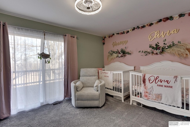 bedroom with a nursery area, carpet flooring, and visible vents