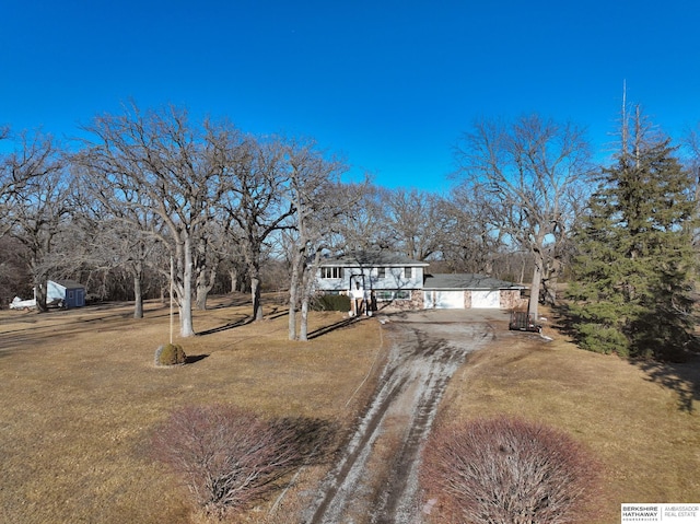 view of front of house featuring a front yard and dirt driveway