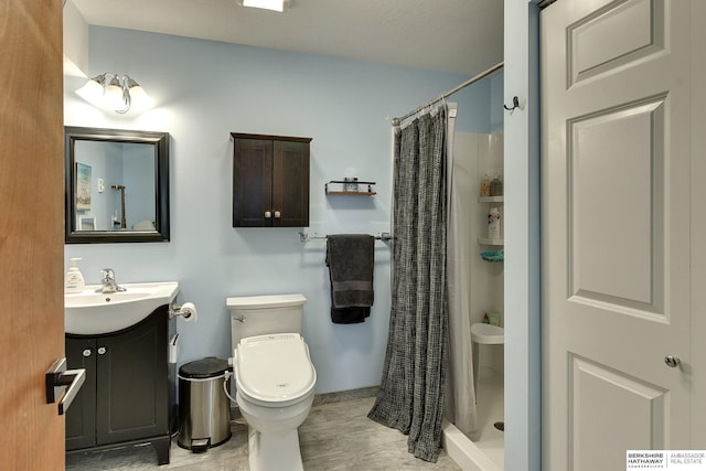 bathroom with a stall shower, vanity, toilet, and wood finished floors