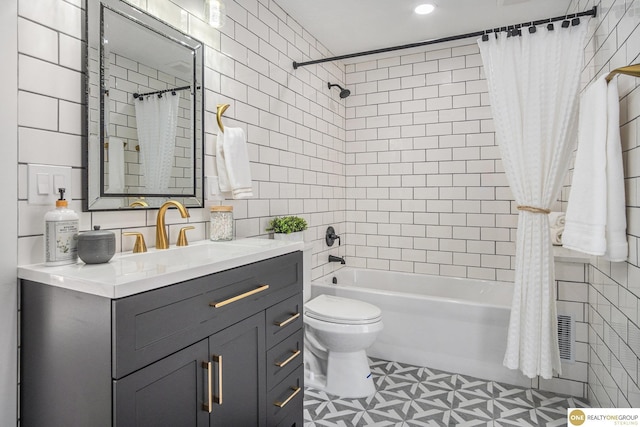 full bath with toilet, vanity, tile walls, and shower / tub combo with curtain