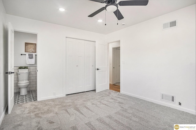 unfurnished bedroom with visible vents, ensuite bath, and carpet flooring