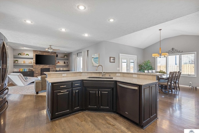 kitchen featuring a fireplace, a sink, built in features, open floor plan, and stainless steel dishwasher