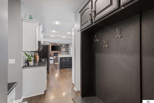 mudroom with dark wood finished floors and recessed lighting