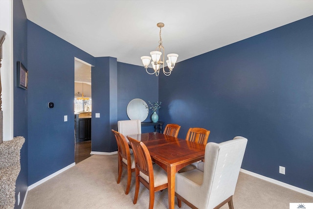 carpeted dining room featuring baseboards and a notable chandelier