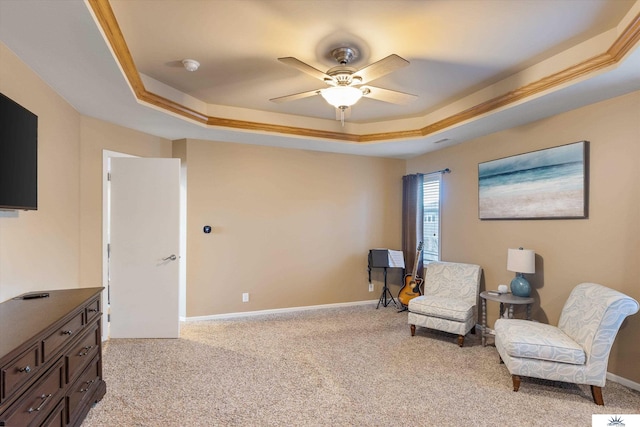 sitting room with light carpet, baseboards, a raised ceiling, and a ceiling fan