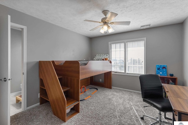 office area with carpet floors, baseboards, visible vents, and a textured ceiling