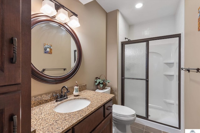 full bathroom featuring toilet, a stall shower, tile patterned flooring, and vanity