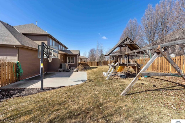 view of yard featuring a patio area, a fenced backyard, and a playground