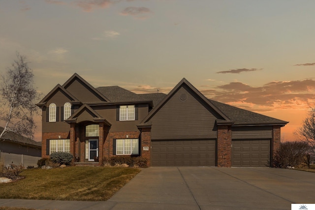 view of front of house with concrete driveway, brick siding, a lawn, and an attached garage