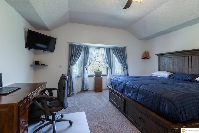 bedroom featuring lofted ceiling, ceiling fan, a textured ceiling, and light colored carpet