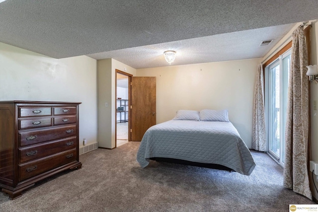 bedroom with a textured ceiling, visible vents, and carpet flooring