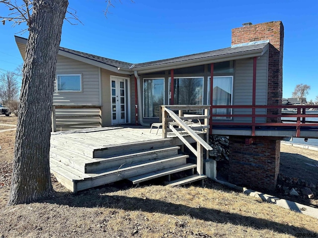 back of property with a deck and a chimney