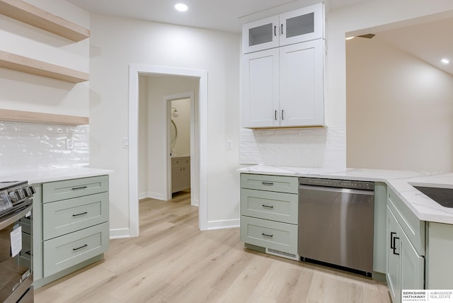 kitchen featuring light stone counters, open shelves, tasteful backsplash, appliances with stainless steel finishes, and light wood-style floors