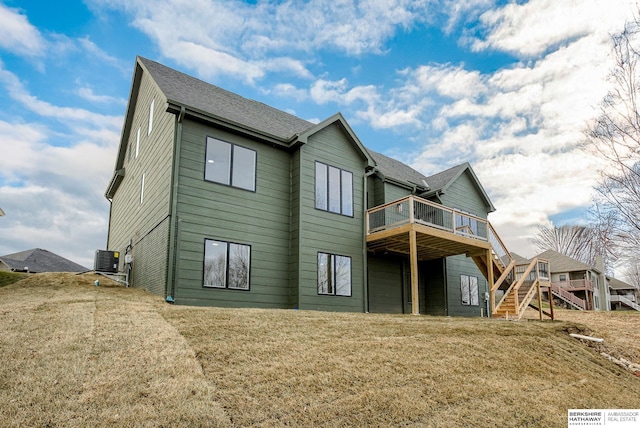 rear view of property with roof with shingles, a lawn, cooling unit, a wooden deck, and stairs