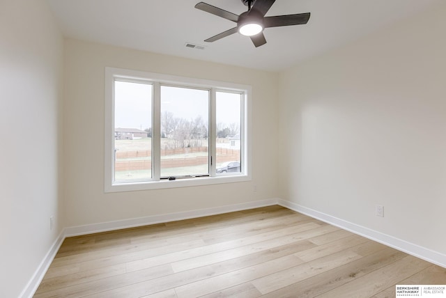 unfurnished room with light wood-style floors, visible vents, baseboards, and a ceiling fan