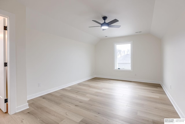 additional living space with lofted ceiling, ceiling fan, light wood finished floors, and baseboards