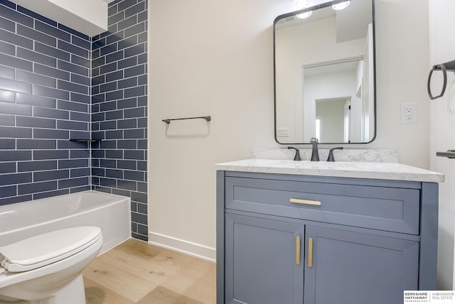 full bathroom featuring toilet, baseboards, wood finished floors, and vanity