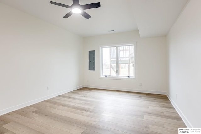 unfurnished room with light wood-style floors, electric panel, and baseboards