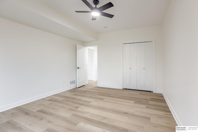 unfurnished bedroom with a closet, baseboards, visible vents, and light wood finished floors