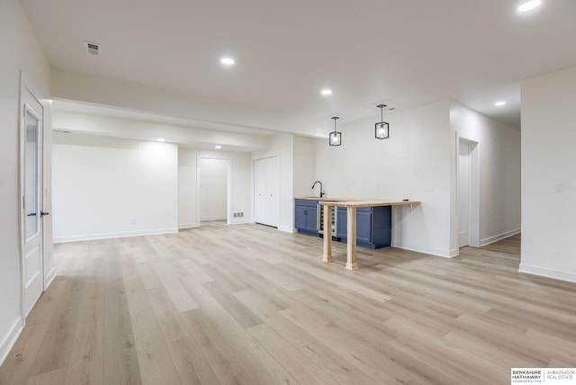 finished basement featuring wine cooler, light wood-style flooring, recessed lighting, visible vents, and baseboards