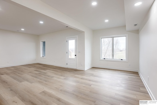 spare room featuring baseboards, recessed lighting, and light wood-style floors