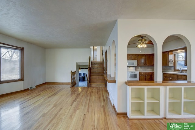 interior space featuring a wealth of natural light, visible vents, light wood-style flooring, and white appliances