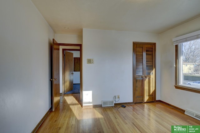 empty room featuring baseboards, visible vents, and light wood-type flooring