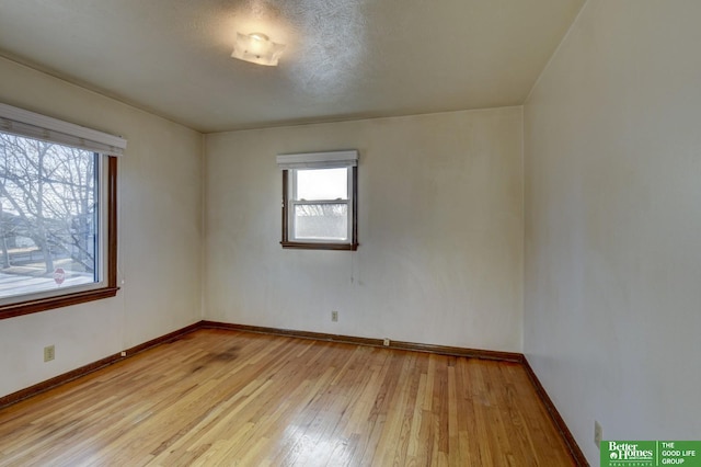 spare room with baseboards and light wood-style floors