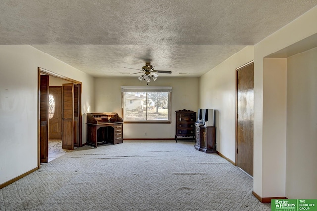 unfurnished living room featuring baseboards, carpet floors, and a textured ceiling