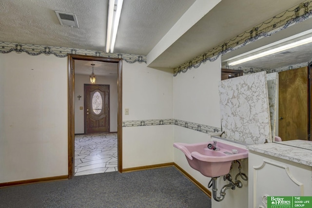 bathroom with visible vents, baseboards, and a textured ceiling