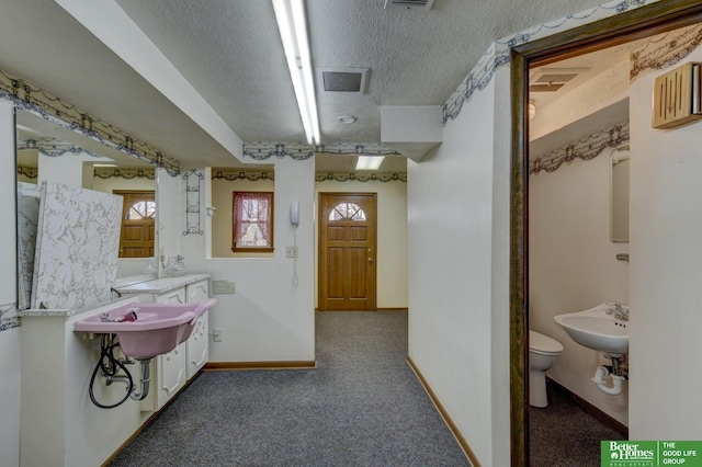 bathroom featuring toilet, a textured ceiling, and baseboards