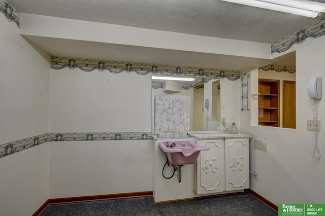 bathroom with baseboards and a textured ceiling