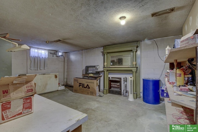 finished basement with a textured ceiling and concrete block wall