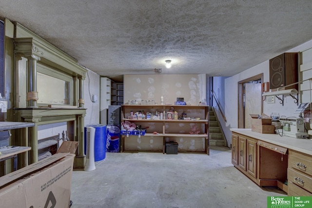 interior space with open shelves, unfinished concrete flooring, a textured ceiling, brown cabinetry, and light countertops