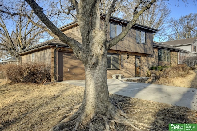 view of front of property featuring brick siding, an attached garage, and concrete driveway