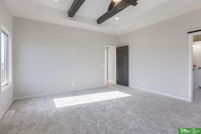 carpeted spare room featuring baseboards, beamed ceiling, a ceiling fan, and a healthy amount of sunlight