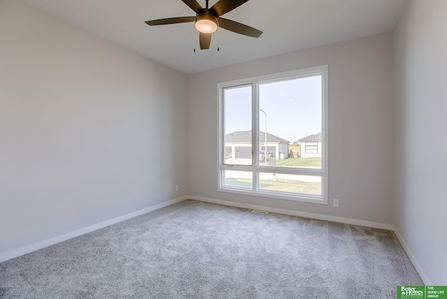 carpeted spare room with ceiling fan and baseboards