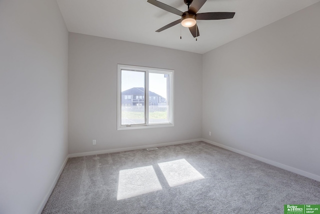 carpeted empty room featuring a ceiling fan and baseboards