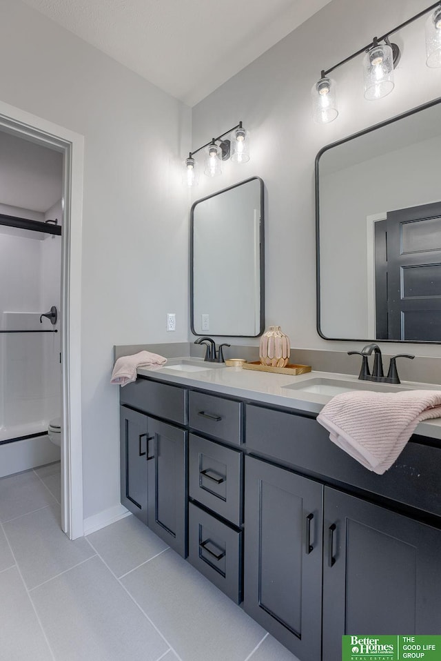 full bathroom featuring double vanity, a sink, a shower with door, and tile patterned floors