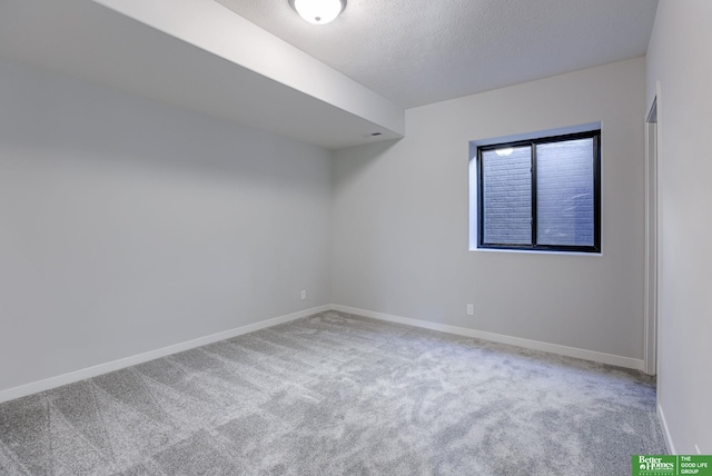 empty room with baseboards, a textured ceiling, and carpet flooring