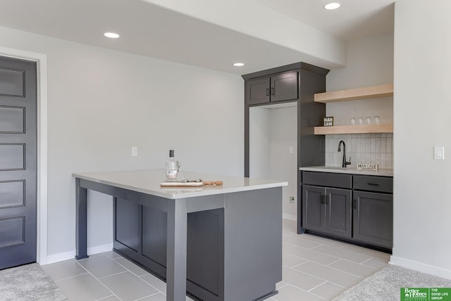 kitchen with recessed lighting, light countertops, light tile patterned flooring, a sink, and a peninsula