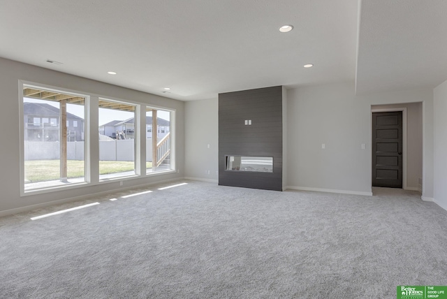 unfurnished living room featuring a fireplace, baseboards, and light colored carpet