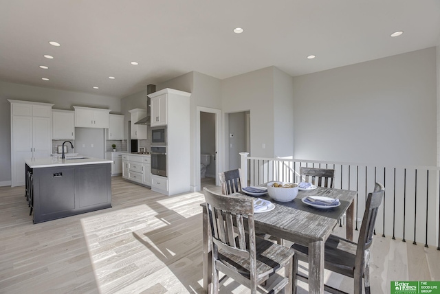 dining room with light wood finished floors and recessed lighting