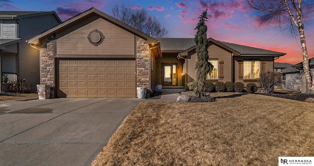 ranch-style house featuring stone siding, an attached garage, and driveway