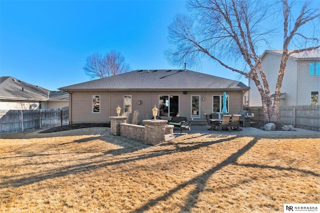 back of house with a shingled roof, a lawn, a patio area, and a fenced backyard