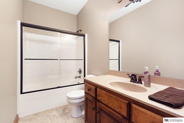 bathroom with enclosed tub / shower combo, vanity, toilet, and tile patterned floors