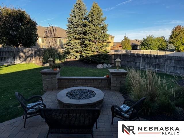 view of patio featuring fence and a fire pit